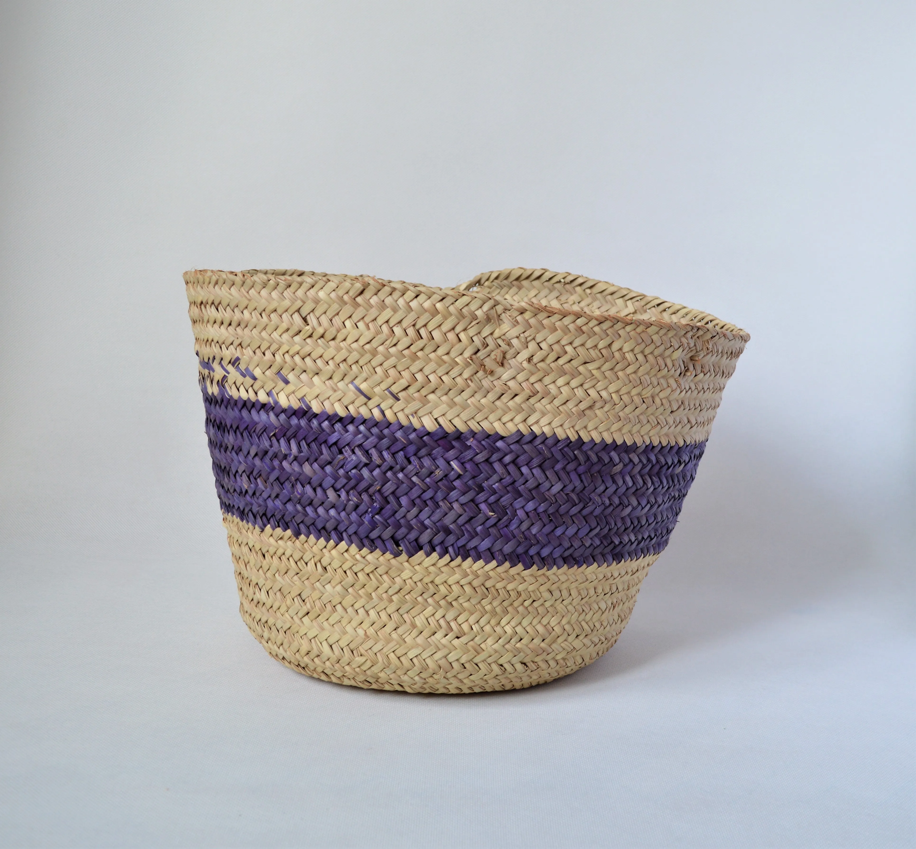 Round straw basket from natural palm leaves with a wide Purple stripe