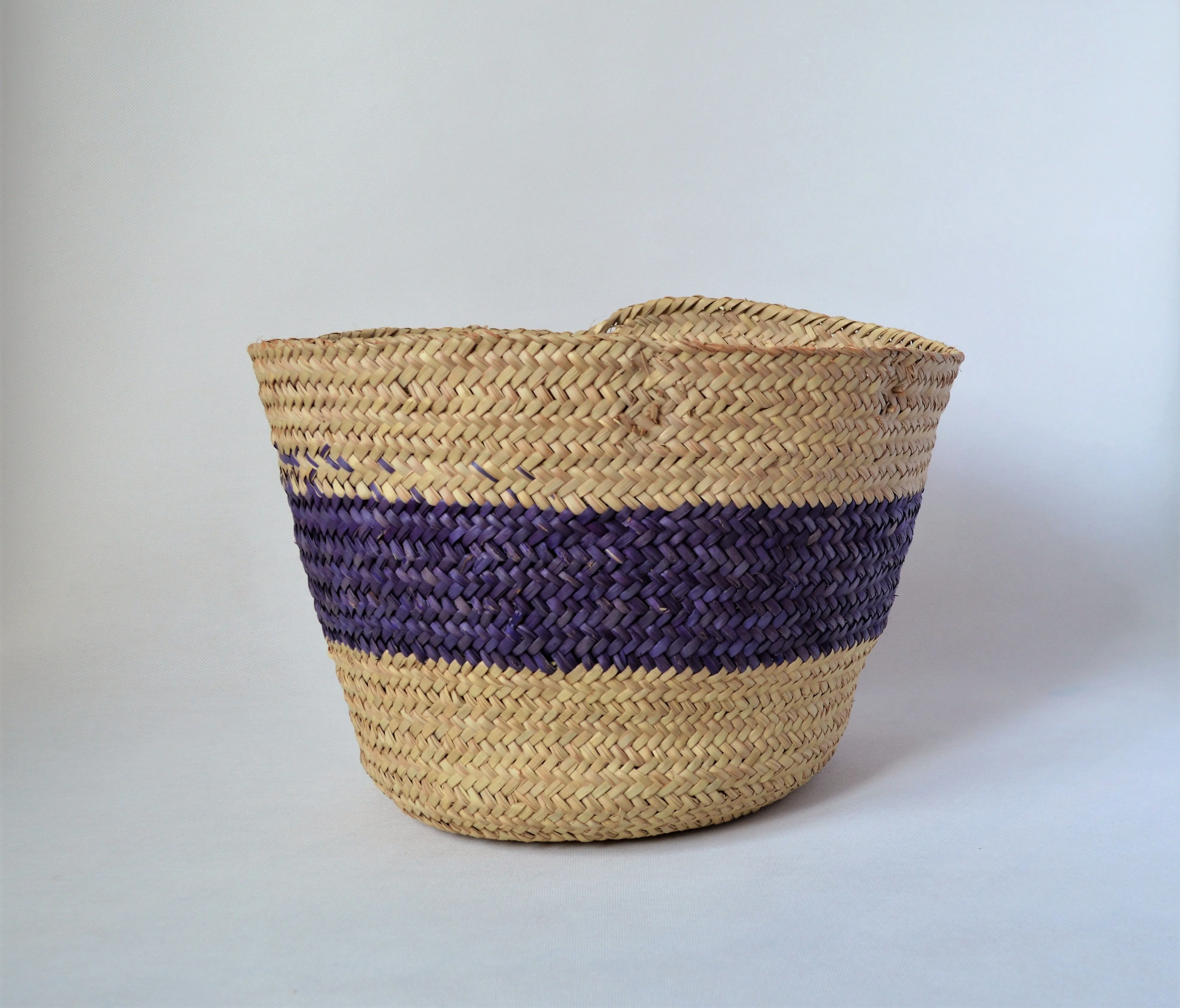 Round straw basket from natural palm leaves with a wide Purple stripe