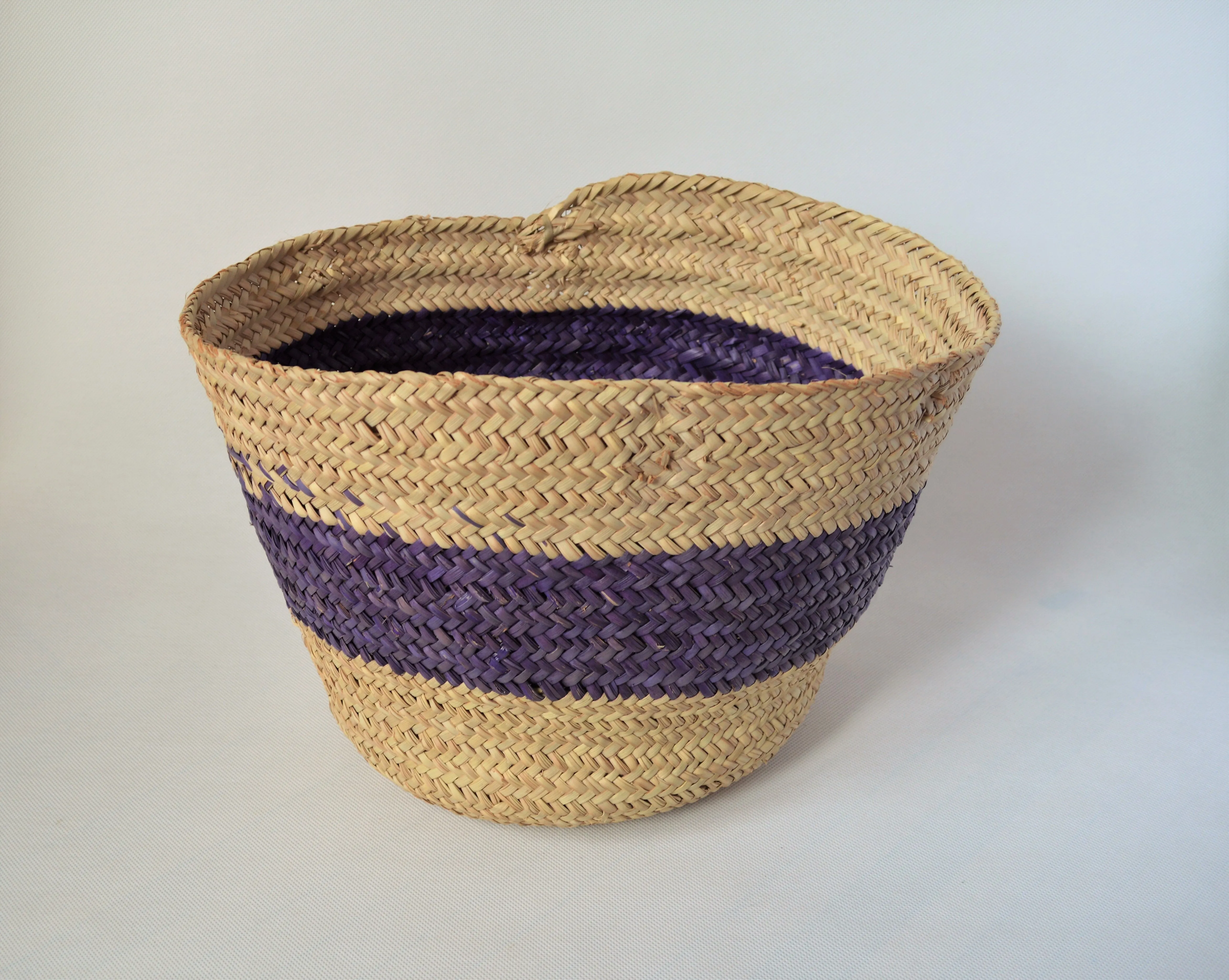 Round straw basket from natural palm leaves with a wide Purple stripe
